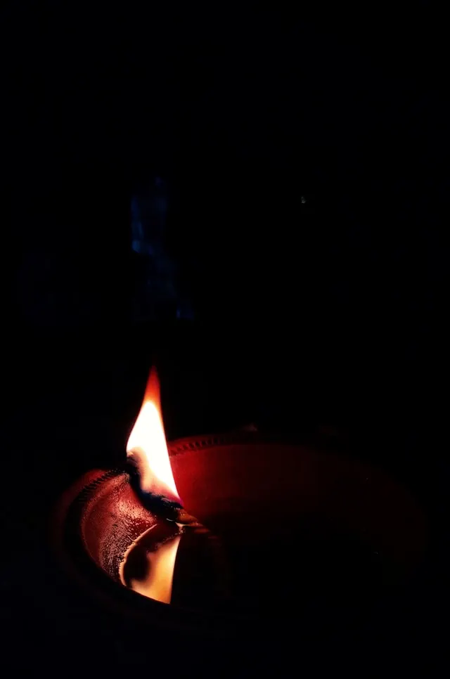 暗闇でロウソクの炎が揺らめく画像