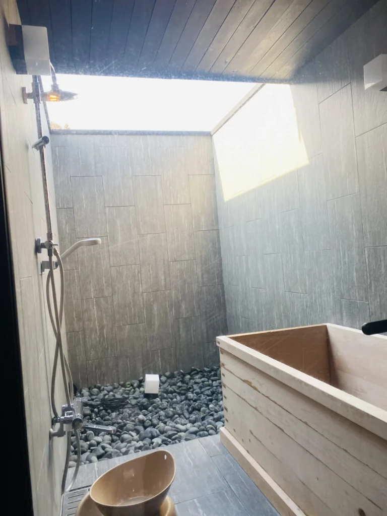 木のバスタブがあり、天井が半分吹き抜けになっていて空が見え家庭の浴室の3倍くらいの広さの浴室