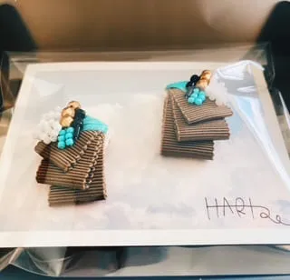 ターコイズブルーの刺繍がポイントのイヤリングがラッピングされている写真