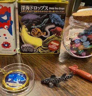 黒い背景にシーラカンスやチョウチンアンコウやメンダコが描かれたパッケージのサクマドロップスと同じ形のドロップ缶