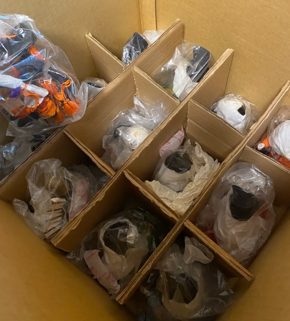 段ボールの底を仕切り板で16区画に分けビニールに包んだお人形を収めた写真