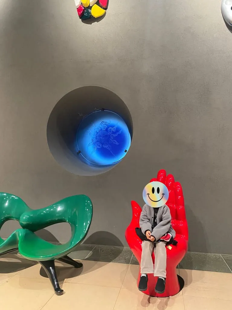 岡本太郎の制作した手の椅子に座る子供の画像